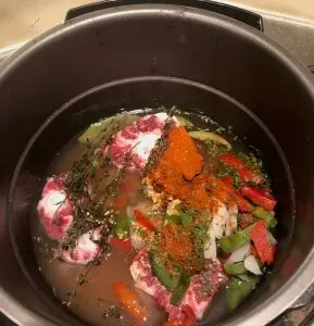 Oxtails with thyme, bay leaf, onions, peppers, seasonings in an instant pot for Single Ingredient Groceries.