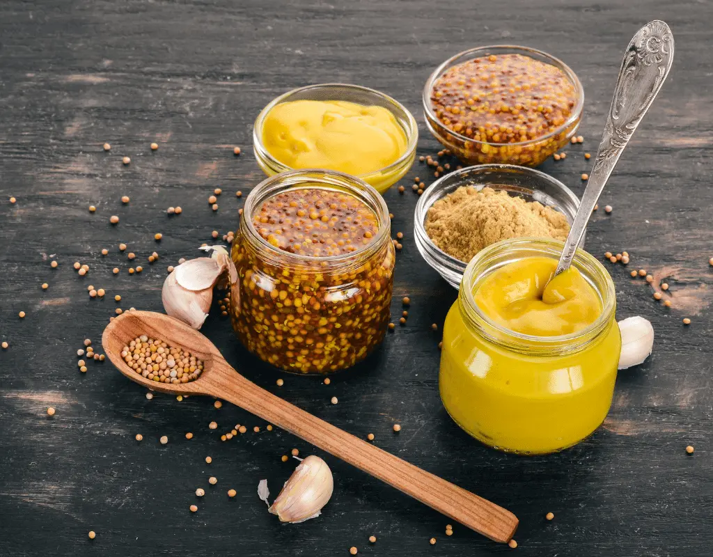 different types of mustard on a wooden table