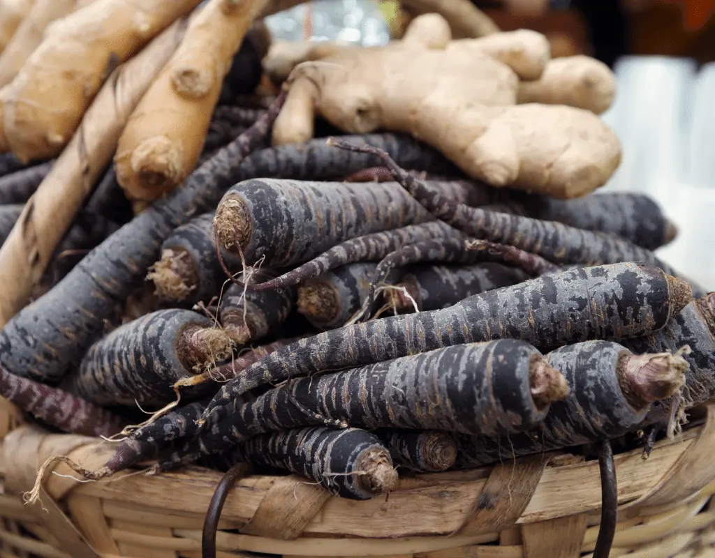 Ginger root and black carrots in a basket