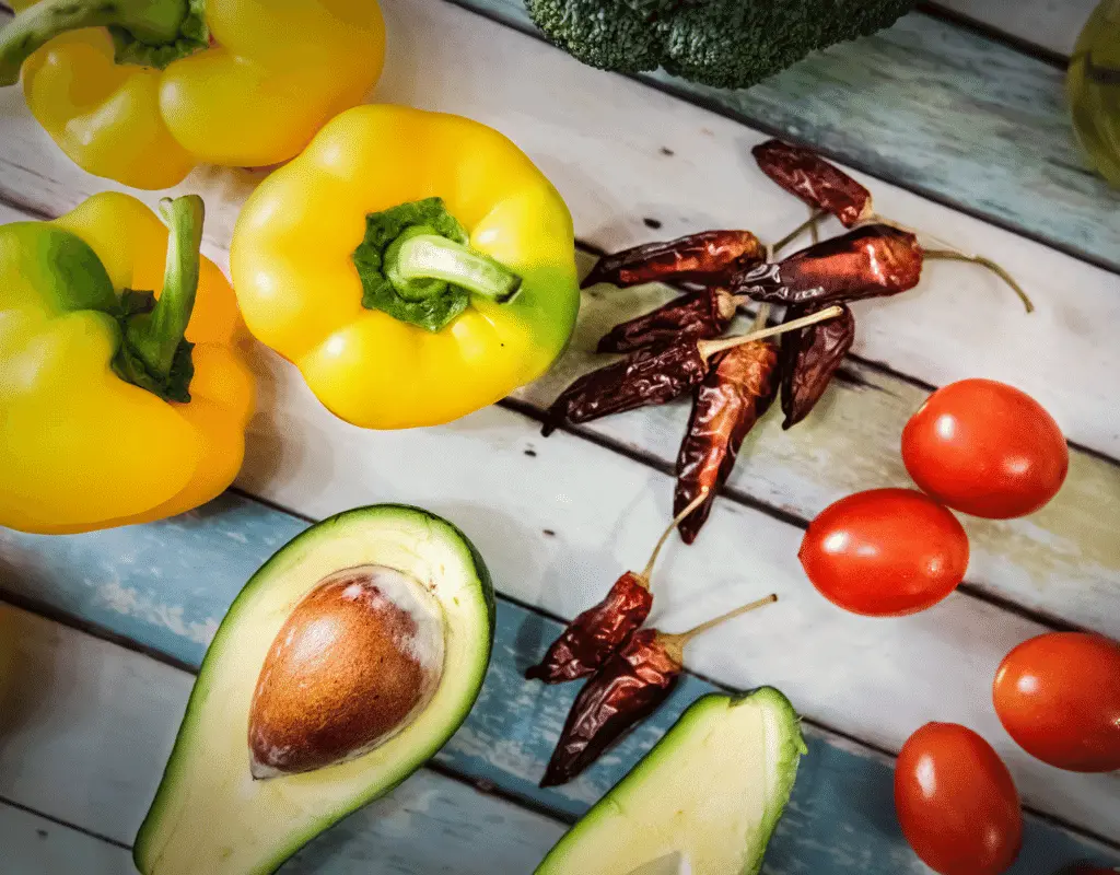 avocados, bell peppers, chili peppers, and tomatoes displayed on wood for avocado allergy
