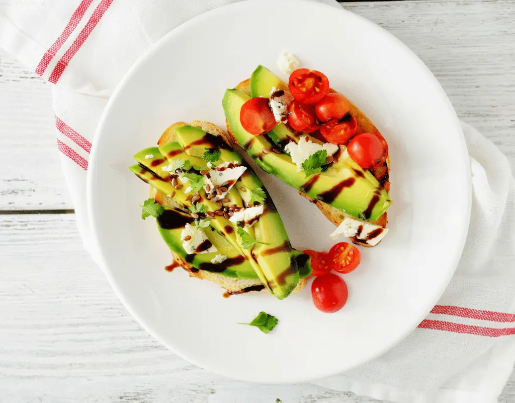 avocado, aged cheese and tomatoes on a white plate