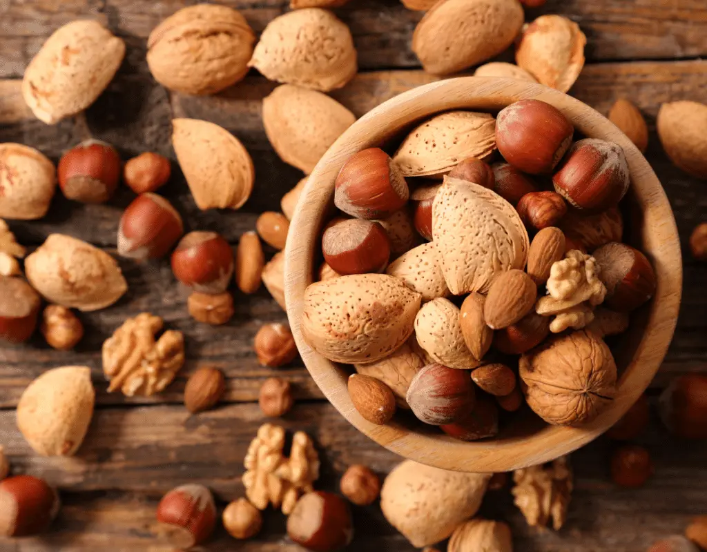 almonds, walnuts, and hazelnuts displayed in a wooden background