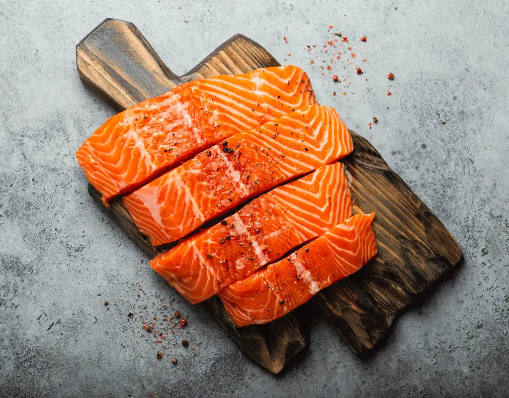 sliced fresh salmon on a wooden cutting board