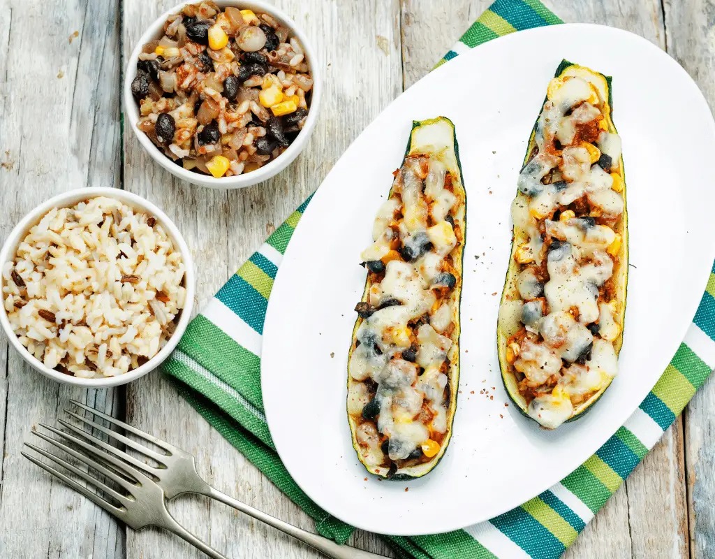 Stuffed zucchini with black beans, corn and cheese along with brown rice side dish