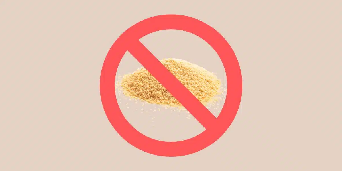 Photo of amaranth seeds / amaranth grain uncooked on tan background with red prohibited symbol / red circle with a line in it for Single Ingredient Groceries blog post about amaranth allergy.