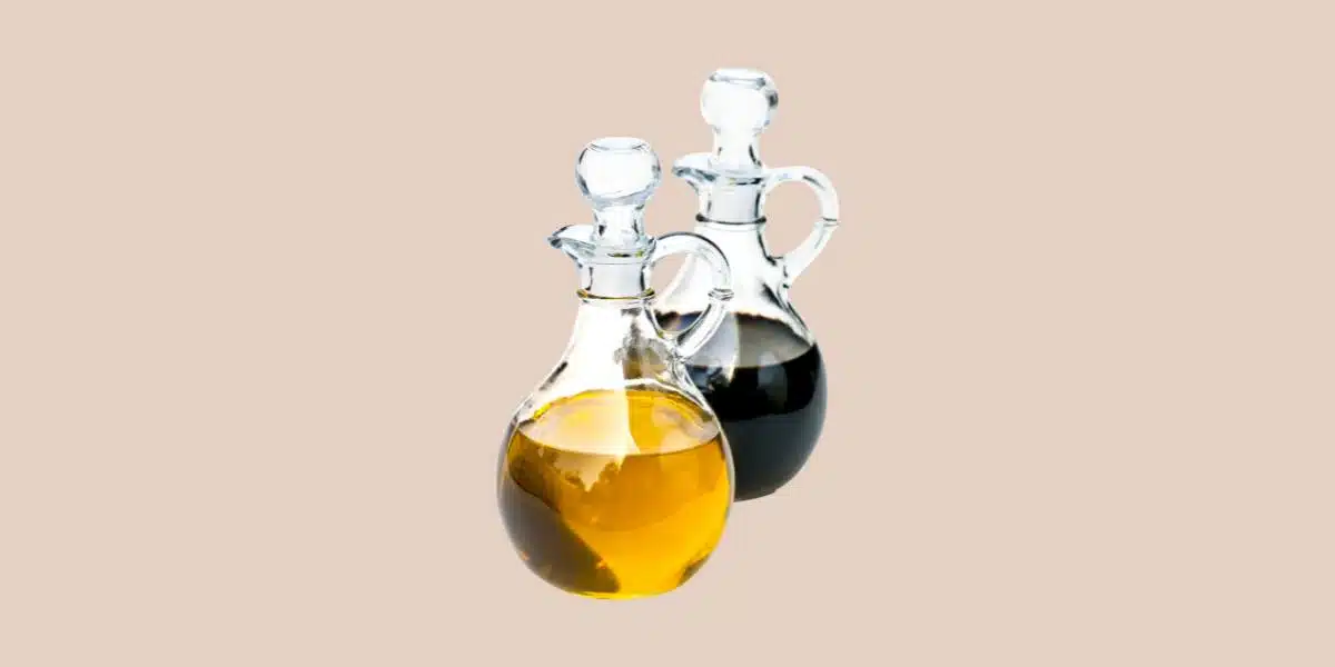 Clear bottles of white balsamic vinegar and traditional dark balsamic vinegar for Single Ingredient Groceries blog post about white balsamic vinegar.